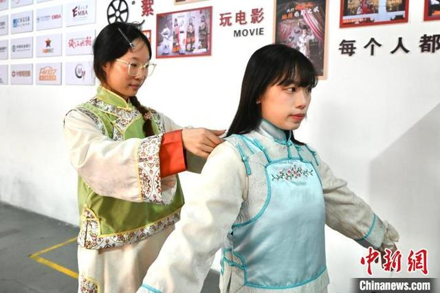 图为两岸青年互相整理戏服。中新社记者 刘子琳 摄