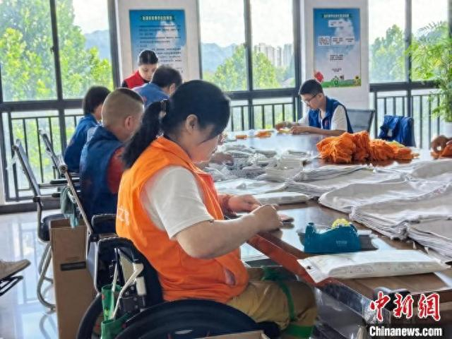 残疾员工在义乌华川集团内拼装毛巾。张煜欢 摄