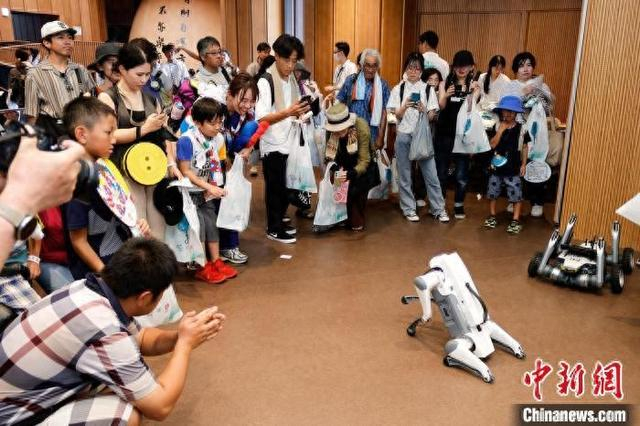 7月13日，2025年日本大阪世博会中国馆“杭州日”系列活动在日本大阪举行。图为观众与机器狗互动。 主办方 供图