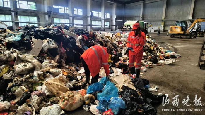 ▲两名环卫工人在垃圾中找寻手表。