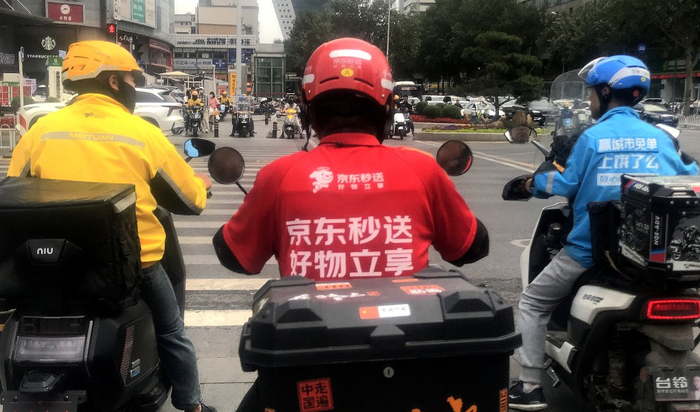 京东、美团、饿了么的外卖配送员在街头相遇。视觉中国 图