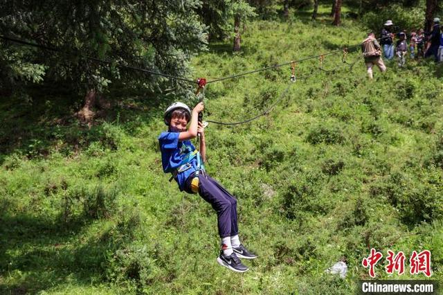 7月15日，小朋友在聚阳沟景区体验滑索。中新社记者 薛蒂 摄