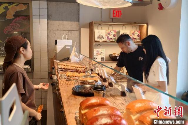 7月14日，Rocco在成都一家面包店，与店员就“剩菜盲盒”进行沟通。中新社记者 吕杨 摄