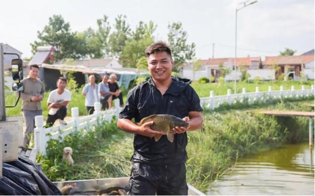 钓台服务人员正在为鱼塘补充渔货。丰县县委宣传部供图