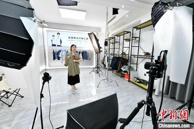 图为7月14日，邯郸市森尚依品服装有限公司的员工正在直播带货。 杜昕雨 摄 