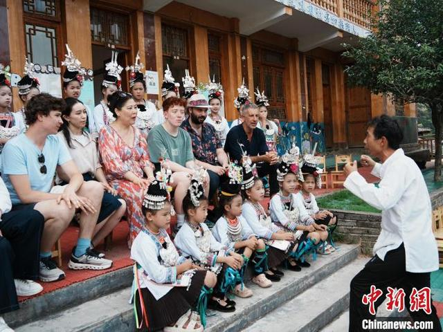 7月15日，来自欧洲国家的音乐人在黄岗侗寨跟着侗族女孩一起学习唱侗族大歌。中新社记者 周燕玲 摄