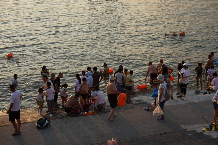 武汉市民在大堤口岸边戏水。邱思宇 摄