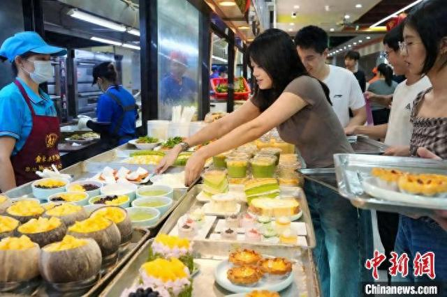 7月12日，参加2025年海南自贸港“逐浪计划”港澳大学生暑期实习活动的大学生在海口品尝“老爸茶”。王海荣 摄