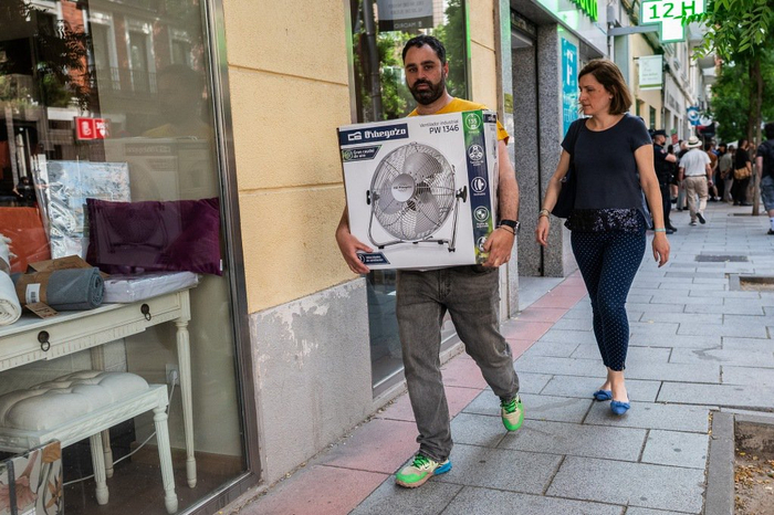 当地时间2025年6月2日，西班牙马德里，一名男子在高温天气中携带电风扇。