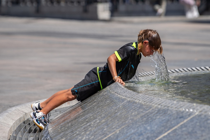 当地时间2025年7月17日，西班牙马德里，一名儿童在太阳门广场的喷泉中消暑。
