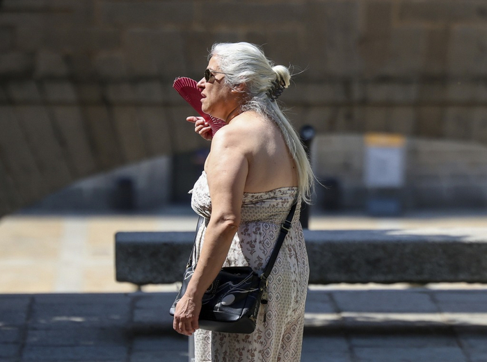 当地时间2025年6月30日，西班牙马德里，一名女子在热浪中扇风。