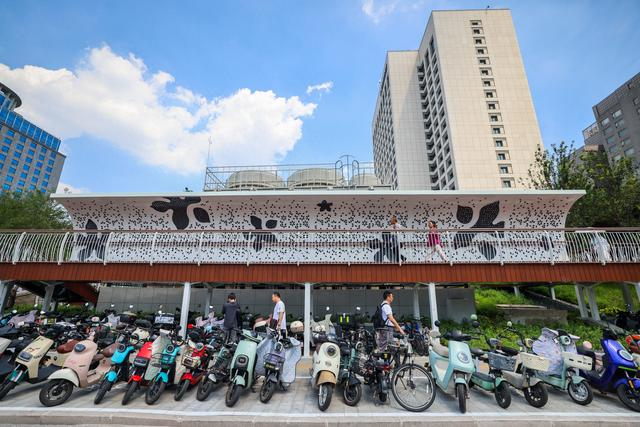 地铁10号线西钓鱼台站C口外增设一处架空栈桥，实现上下行客流分离，周边非机动车停车区扩容，加强轨道交通接驳能力。邓伟摄