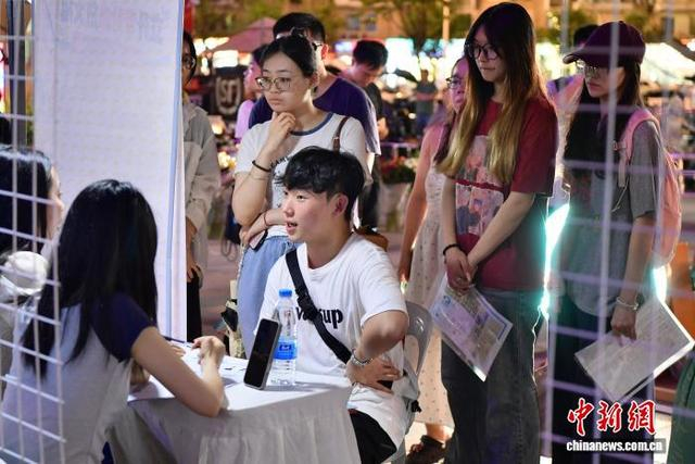 图为求职者与企业工作人员交谈。中新社记者 张斌 摄