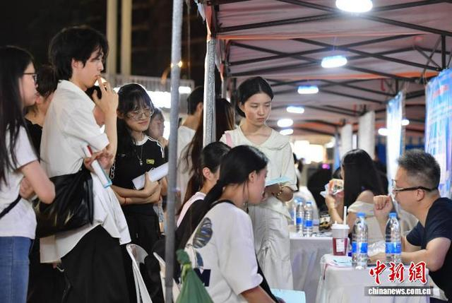 图为求职者在咨询招聘岗位情况。中新社记者 张斌 摄
