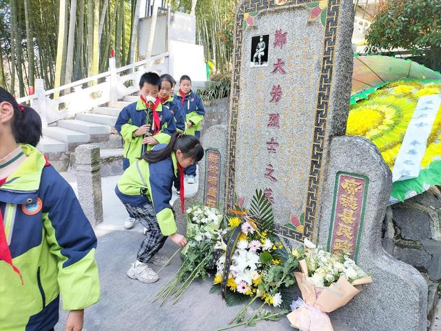 学生在郑大芳烈士墓前敬献鲜花。（受访单位供图）
