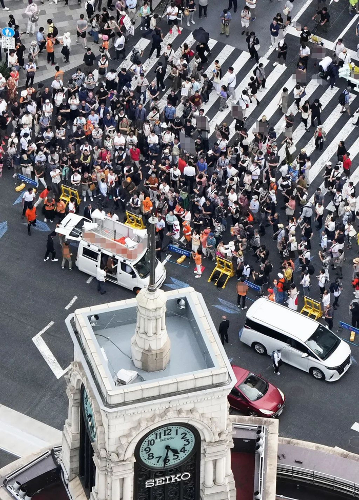 当地时间2025年7月19日，日本东京银座，日本参议院选举前一天，民众在听取一名政客的演讲。视觉中国 图