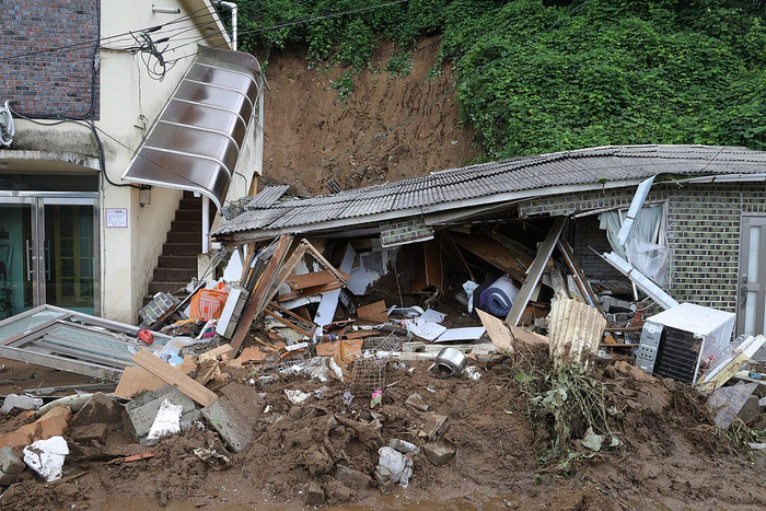 当地时间2025年7月20日，韩国京畿道加平郡，当地政府工作人员帮助因暴雨被困在当地住宿设施的游客撤离到安全区域。