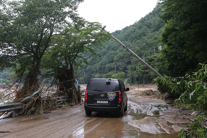 当地时间2025年7月21日，韩国京畿道加平郡大宝桥附近，一根电线杆在洪灾现场倒塌。