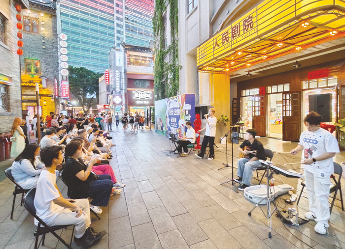     游客在人民剧院门口观赏乐队表演。    本报记者梁枫 摄