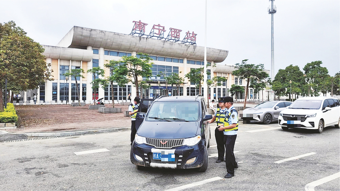     执法人员对投诉车辆进行检查。    （邓小燕 摄）