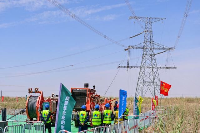 施工人员在新疆和田地区民丰县架设民丰—且末750千伏线路最后一段电线（2025年7月13日摄）。新华社记者 丁磊 摄