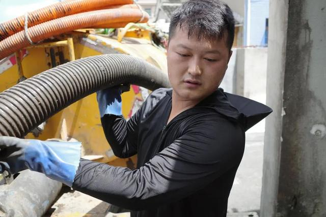 工作时，潘浩男需要拖着几十公斤重的抽粪管 红星新闻记者 付垚 摄