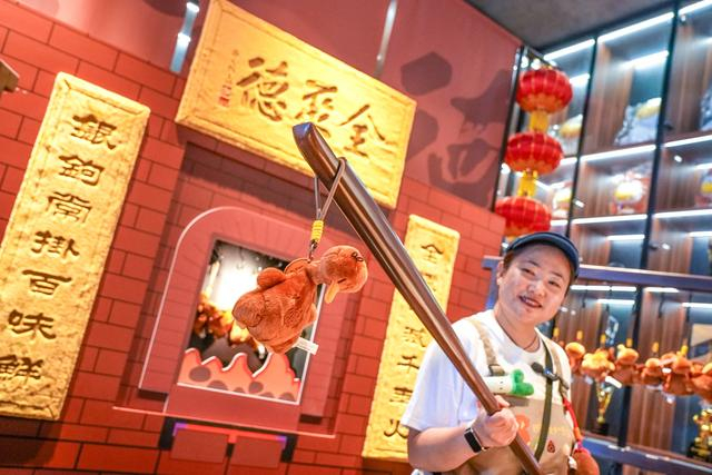 店员角色演绎片鸭仪式，让顾客在互动中感受非遗。 本报记者 武亦彬摄