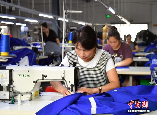 7月19日，河北省邯郸市冀南新区光禄镇一企业生产车间内，工人正在生产劳保服装。 韩冰 摄