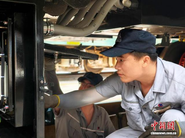 图为检车员对车下电池箱进行检查。 焦瑛敏 摄