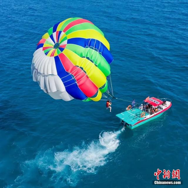 在万宁加井岛体验海上拖伞！随着快艇加速升空，感受海风拂面的自由与心跳加速的畅快。寰球拓海供图