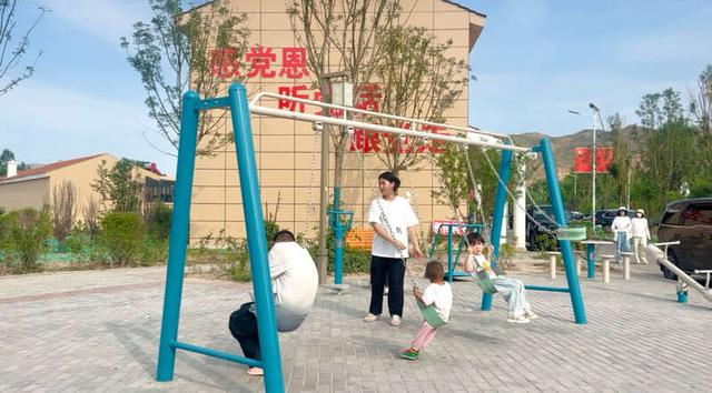 7月23日下午，青海省民和县中川乡金田新村感恩广场前，孩子们在荡秋千。中青报·中青网记者 郝帅/摄
