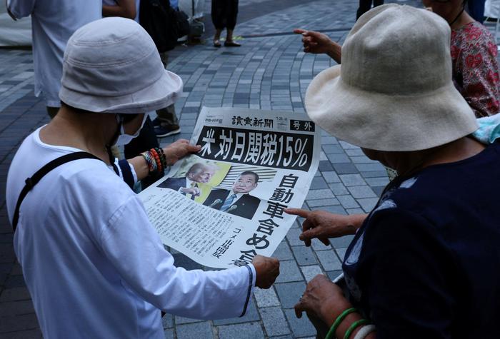 当地时间2025年7月23日，日本东京，市民阅读《读卖新闻》刊登的美日达成贸易协议的新闻。图/IC photo