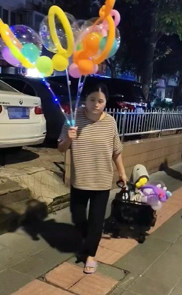 2025年7月，郭惠担心乐宝撞破头上的包，傍晚出门卖气球时常把他放在儿童车里。 受访者供图