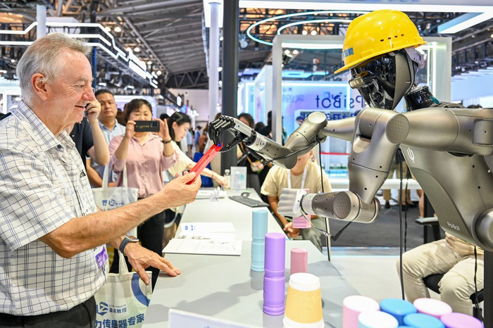 2025年7月26日，上海世博展览馆，机器人为观众递上礼物。澎湃新闻记者 朱伟辉 图