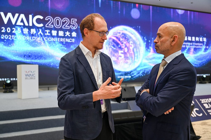 2025年7月26日，上海世博展览馆，人工智能的数学边界与基础重构论坛，两名外籍嘉宾在交流。澎湃新闻记者 朱伟辉 图