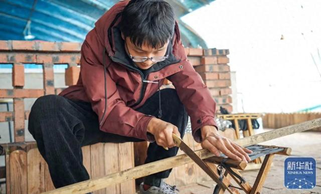 ▲4月28日，王储在钓虾池旁边锯木桩，为钓虾场五一小长假开业做准备。