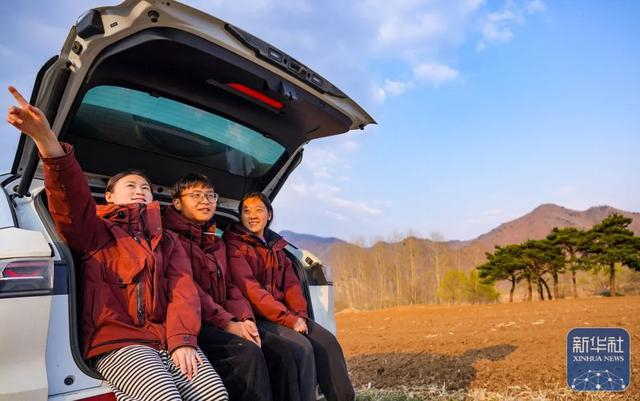 ▲4月28日，耿飞飞（左一）、王储、王佳玉（右一）在北兴村的稻田边畅想未来。