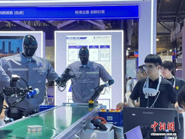 7月25日，记者提前探馆，现场工作人员正在调试人形机器人。中新网记者 郑莹莹 摄