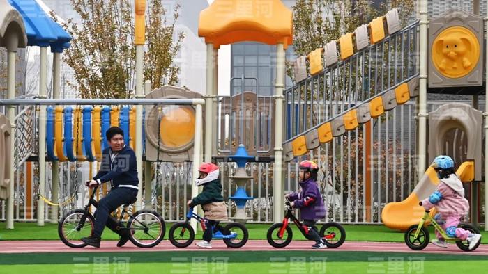 河北省雄安某幼儿园内,老师与孩子们体验平衡车。图/中新社记者 翟羽佳 摄