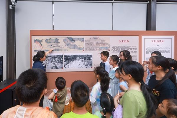 7月20日，位于北京中轴线上的正阳桥遗址考古方舱内，小学生们在听取讲解，学习历史知识，感受行走的思政课。视觉中国供图