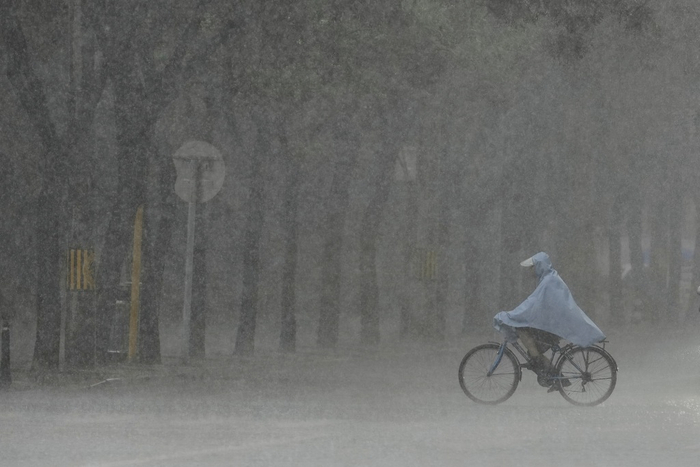 7月27日，北京，一名男子在大雨中骑车出行。视觉中国 图