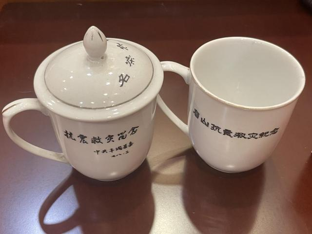 刘国华与高兴旺各自珍藏的唐山抗震救灾纪念杯。澎湃新闻记者郑问 摄 
