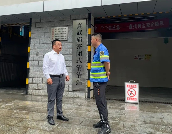 △勤克（左）调研北京市西城区真武庙密闭式清洁站，了解垃圾分类处理相关情况。（图片由受访者提供）