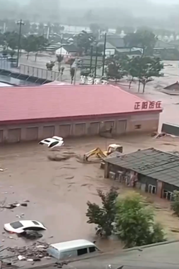 7月28日早，在北京密云太师屯镇，暴雨引发的山洪造成小区车辆被冲走。央视新闻 截屏图