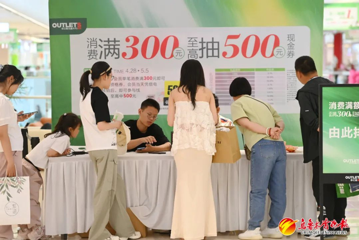 5月5日，在砂之船（乌鲁木齐）奥莱，消费者正在兑换优惠券。
