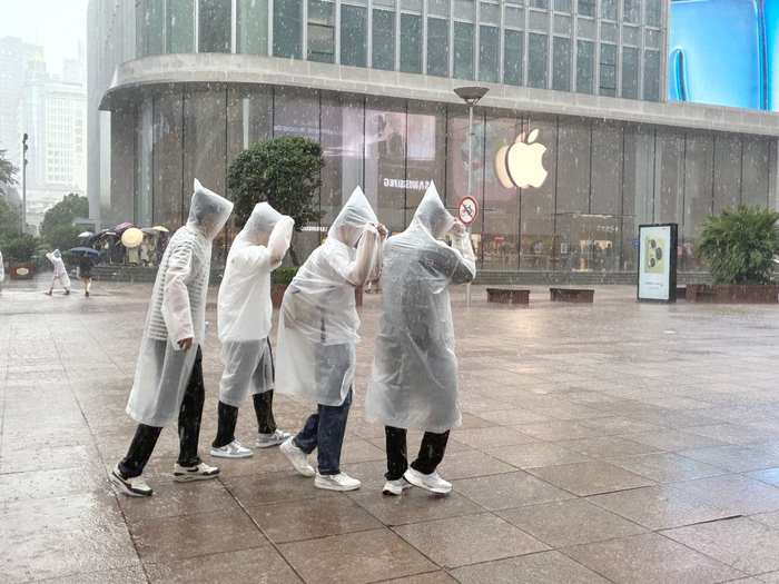 7月30日下午，上海南京东路，行人裹着一次性雨衣在路上行走。