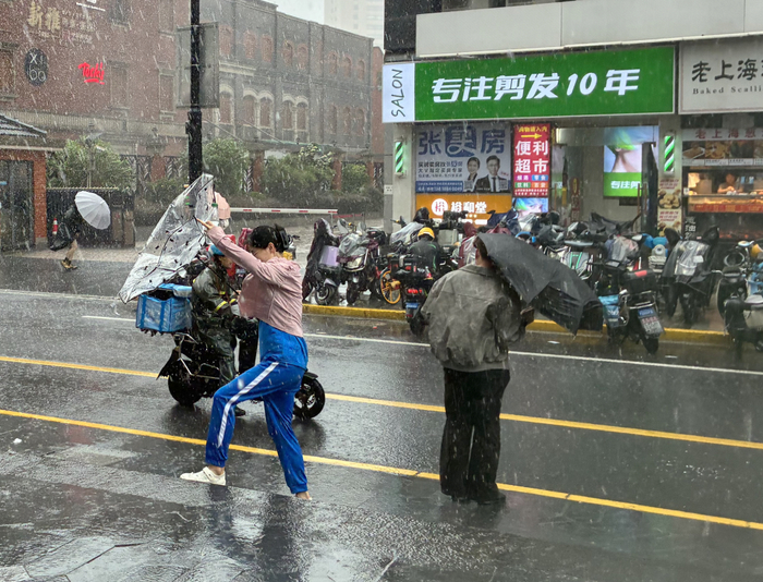 7月30日下午，上海茂名路，行人顶风出行。