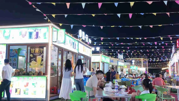 北港故里美食夜市里，人潮涌动的食客围坐在餐桌旁，有人细嚼慢咽品味滋味，有人谈笑风生分享美食，一派热闹鲜活的景象。