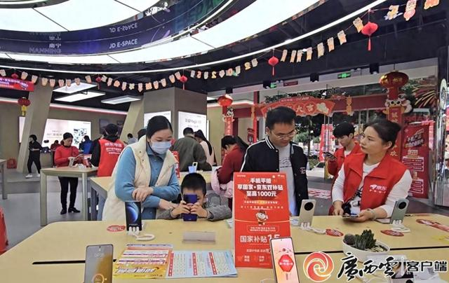 以旧换新补贴极大地激发居民消费热情。图为今年1月消费者在南宁一家商场选购手机。记者 刘冬莲摄
