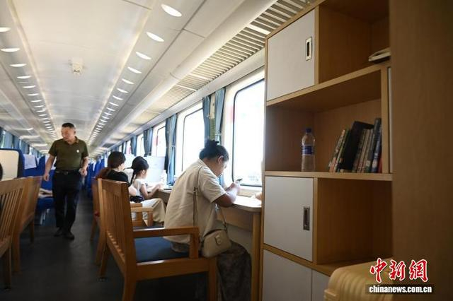 图为乘客在5609次列车的“学习车厢”内阅读。张旭摄